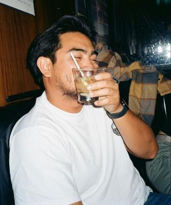 A man drinking a drink in a bar