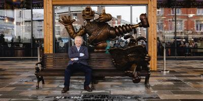 Nick Park sat on the Wallace and Gromit bench  in Preston in September 2021.